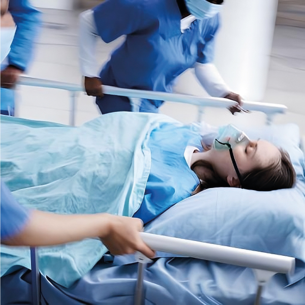 Medici in camici blu trasportano un paziente traumatizzato su barella, evidenziando l'importanza di rapidità, comfort e tecnologie avanzate nell'assistenza d'emergenza.